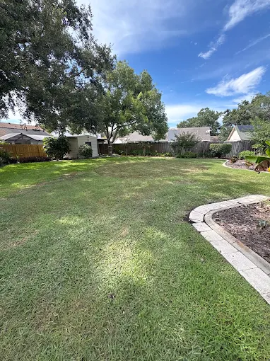 Wide backyard freshly mowed with clean bed edging