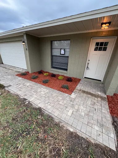 Paver walkway with fresh red mulch and new plantings at a front entry